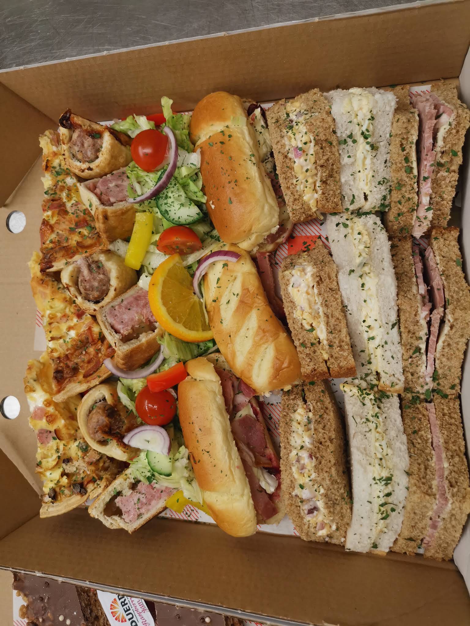 A whole box of sandwiches and savoury food in a photograph uploaded by The Lanes